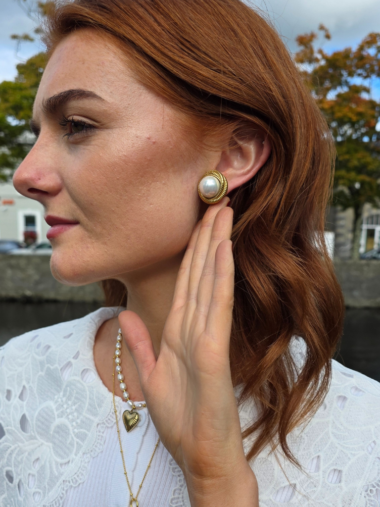Woman in ireland wearing gold silver and pearl necklaces and earrings with matching ring