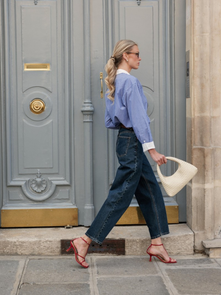 Woman in Ireland wearing dark denim jeans with a chic shirt and handbag